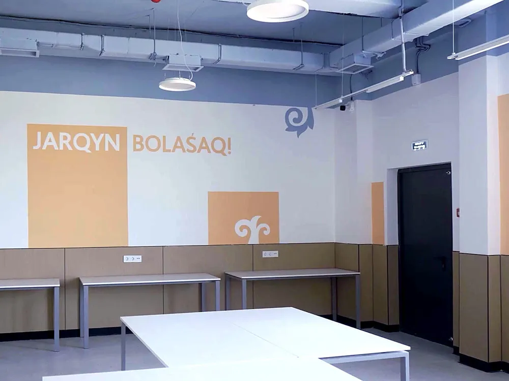 Зал с надписью JARQYN BOLASAQ и открытым потолком