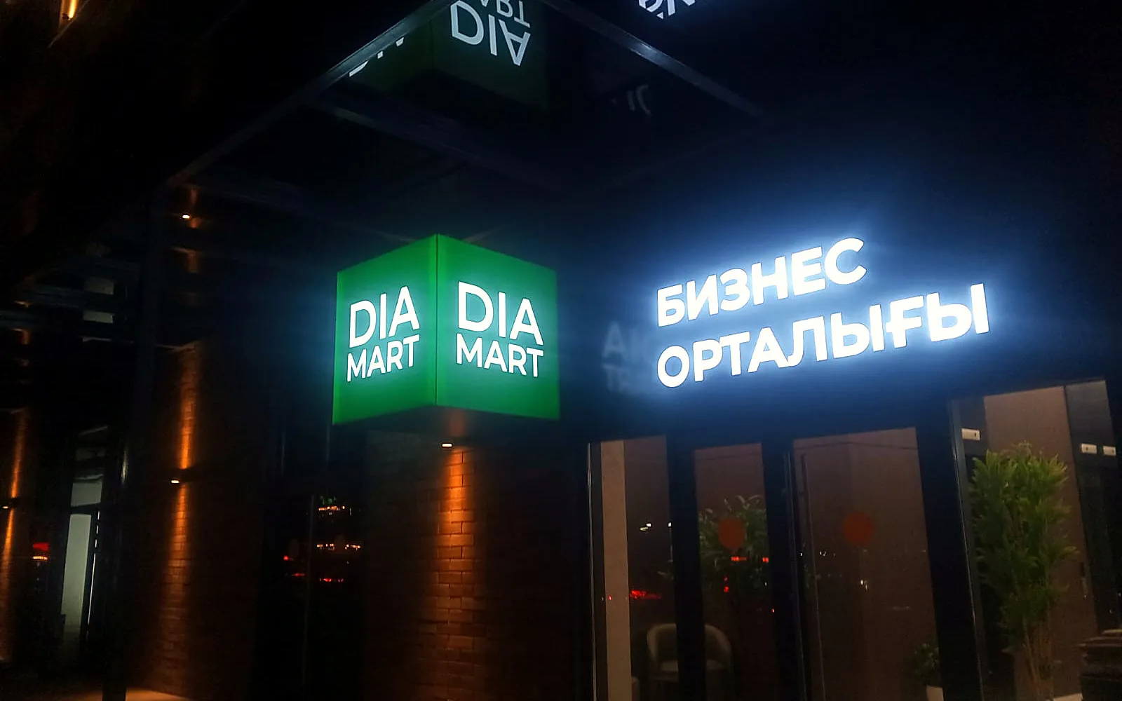 Фасадная вывеска DIA MART с подсветкой ночью