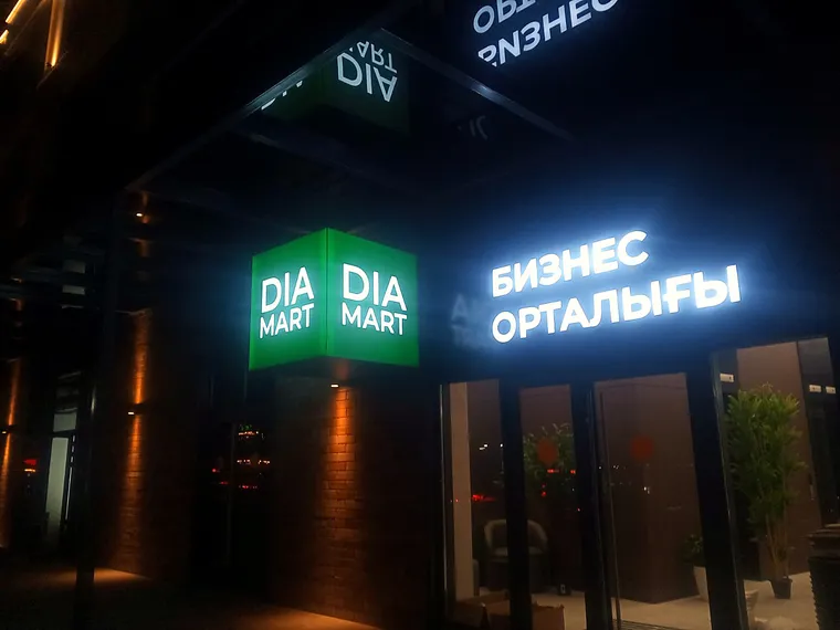 Фасадная вывеска DIA MART с подсветкой ночью