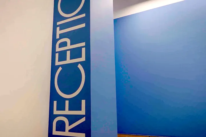 Ресепшн после работ: синяя стена с надписью RECEPTION